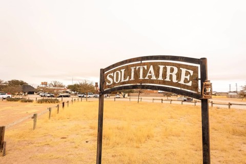 The remote desert settlement of Solitaire in Namibia features a sign displaying the town's name,