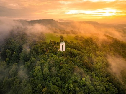 A foggy morning with a tower surrounded by green hills, Schönbergturm, Pfullingen, Swabian Alb,