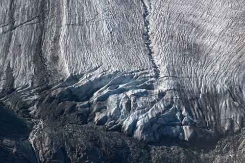 Impressive scene shows lines and textures on residual ice cream in mountains. Daylight emphasises
