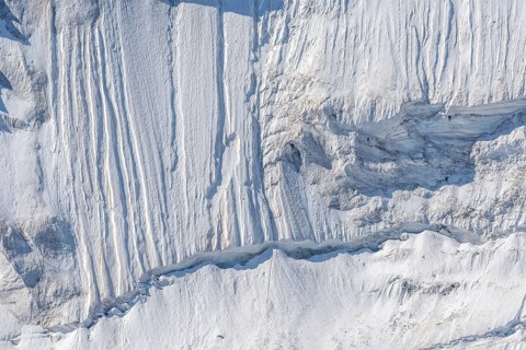 Impressive scene shows lines and textures on residual ice cream in mountains. Daylight emphasises