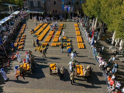Market event in a city centre with cheese sellers and spectators on a sunny day, aerial view,