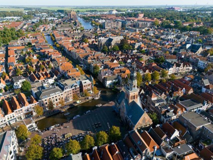 Expansive city view with a central church tower and neighbouring houses, aerial view, former city