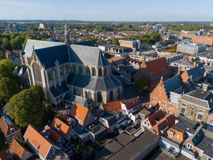 Large church in the middle of a cityscape with traditional houses and green trees, Aerial view,