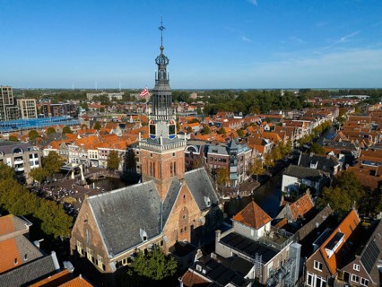 City view with a church tower surrounded by canals and red tiled roofs, aerial view, former city