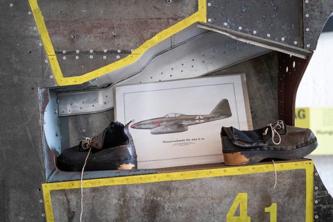 Wooden shoes of a forced labourer standing on an aircraft wing, documentation centre in the old