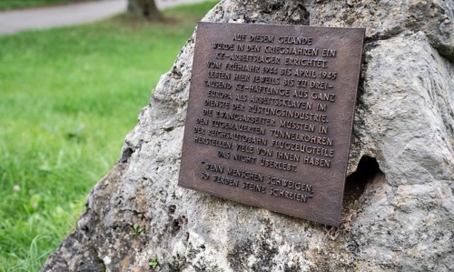 Close-up, stone with memorial plaque to forced labourers in a concentration camp, station on the
