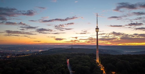 TV tower above wooded area at sunrise with dramatic sky, Stuttgart-Degerloch, Baden-Württemberg,