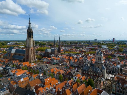 View of the city centre with several churches and red roofs on a cloudy day, aerial view, Nieuwe