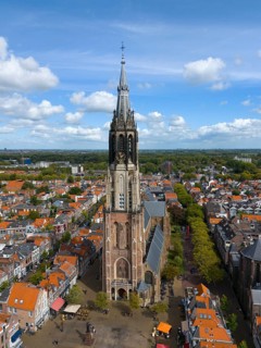 Aerial view of a church tower in the middle of a busy city with red roofs, Aerial view, Nieuwe