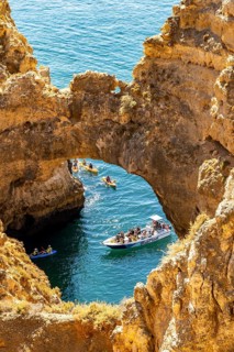 Crowds of excursion boats at the caves and rocky gates of the Ponta da Piedade rocky coast, rugged