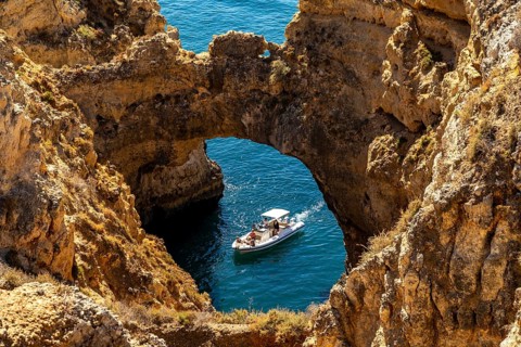 Excursion boats at the caves and rocky gates of the Ponta da Piedade rocky coast, rugged coastal