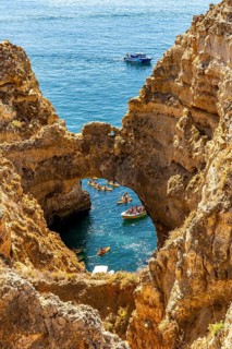 Crowds of excursion boats at the caves and rocky gates of the Ponta da Piedade rocky coast, rugged
