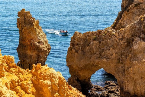 Excursion boats at the caves and rocky gates of the Ponta da Piedade rocky coast, rugged coastal