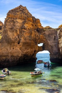 Excursion boats at the caves and rocky gates of the Ponta da Piedade rocky coast, rugged coastal