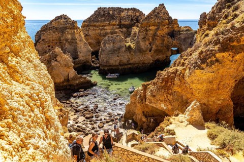 Excursion boats at the caves and rocky gates of the Ponta da Piedade rocky coast, rugged coastal