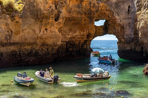 Excursion boats at the caves and rocky gates of the Ponta da Piedade rocky coast, rugged coastal