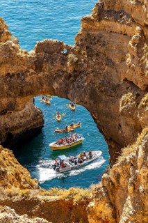 Crowds of excursion boats at the caves and rocky gates of the Ponta da Piedade rocky coast, rugged