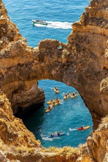 Crowds of excursion boats at the caves and rocky gates of the Ponta da Piedade rocky coast, rugged