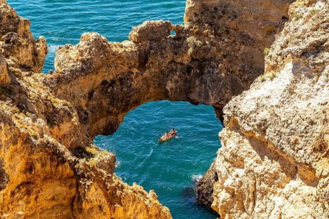 Excursion boats at the caves and rocky gates of the Ponta da Piedade rocky coast, rugged coastal