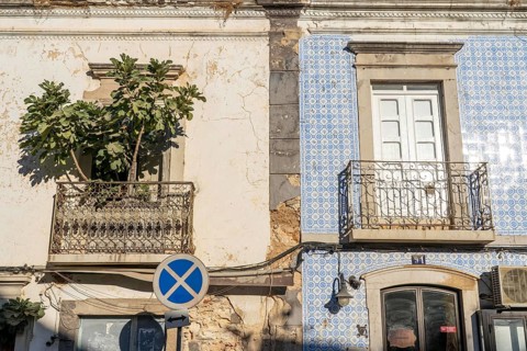 Facade of buildings decorated with tiles, azulejos, coloured tiles on facades, in Tavira, old town,