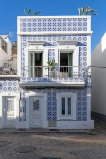 Facade of buildings decorated with tiles, azulejos, coloured tiles on facades, in Tavira, old town,