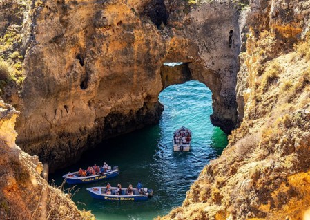 Excursion boats at the caves and rocky gates of the Ponta da Piedade rocky coast, rugged coastal