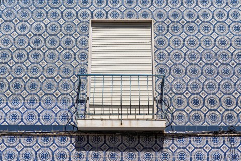 Facade of buildings decorated with tiles, azulejos, coloured tiles on facades, in Tavira, old town,