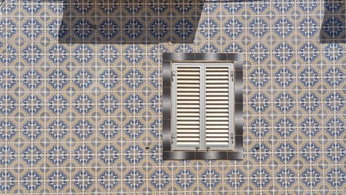 Facade of buildings decorated with tiles, azulejos, coloured tiles on facades, in Tavira, old town,
