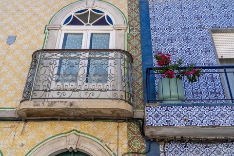 Facade of buildings decorated with tiles, azulejos, coloured tiles on facades, in Tavira, old town,
