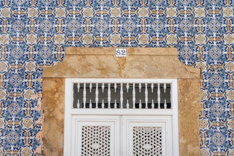 Facade of buildings decorated with tiles, azulejos, coloured tiles on facades, in Tavira, old town,