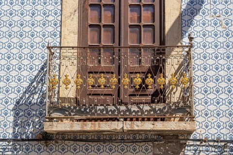 Facade of buildings decorated with tiles, azulejos, coloured tiles on facades, in Tavira, old town,