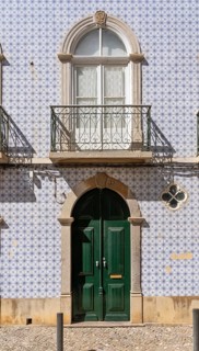 Facade of buildings decorated with tiles, azulejos, coloured tiles on facades, in Tavira, old town,