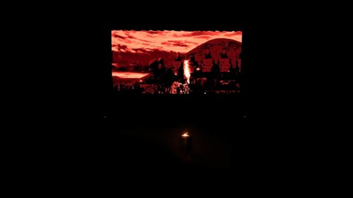 Dancers from Fire of Anatolia perform a choreography in red costumes with a historic stone wall