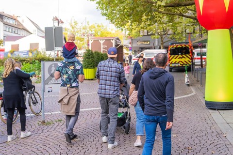 Group of people strolling through town with prams and children on their shoulders, Sindelfingen,