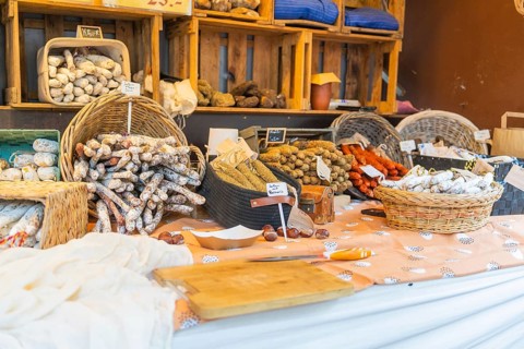 Various types of sausage presented on a market stall with baskets and wooden crates, Sindelfingen,