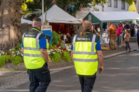 Two people in safety waistcoats on a market square, Sindelfingen, Böblingen district, Germany