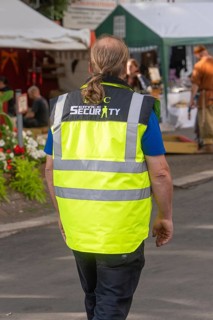 Person in yellow safety waistcoat on a market square, Sindelfingen, Böblingen district, Germany