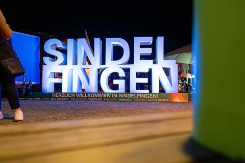 Illuminated welcome sign at night with colourful surroundings and festive atmosphere, Sindelfingen,