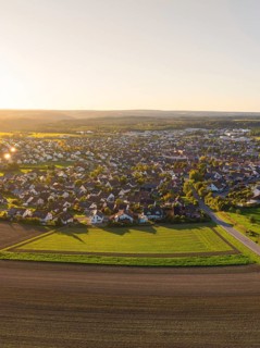 Aerial view of a village surrounded by fields at sunset with rural charm, Althengstett, district of