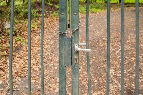Borken, NRW, Germany, Old metal gate closed with a chain and handle, blocking a path in the forest