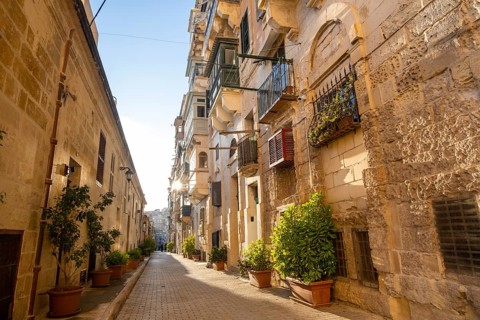 Street with wonderful historic houses with colorful wooden balconies in La Valletta, capital city
