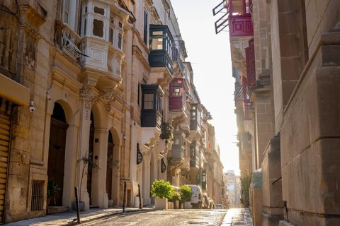Street with wonderful historic houses with colorful wooden balconies in La Valletta, capital city
