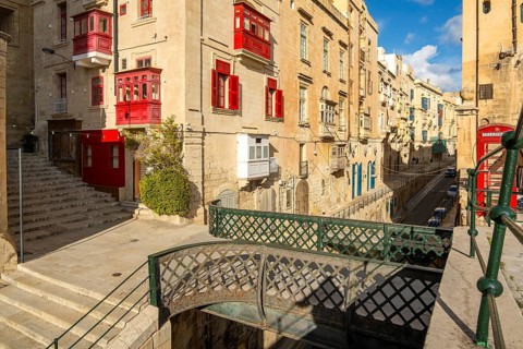 Street with incredible historic houses with colorful wooden balconies in La Valletta, capital city