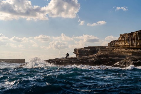 Coast with fishermen next to Marsaxlokk, southern part of Malta