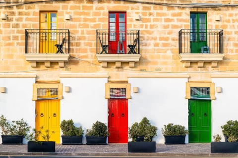 Limestone building with colorful doors in Marsaxlokk, fisherman village on Malta