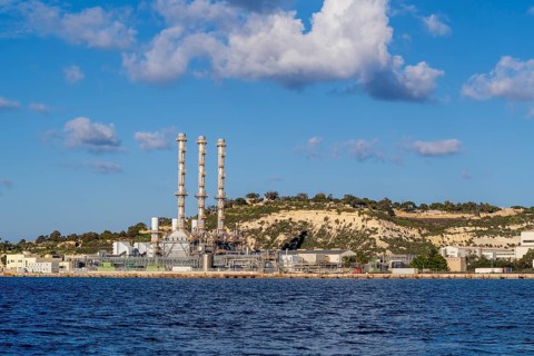 Waterfront power station against blue sky, with copy space, near to Marsaxlokk, Malta