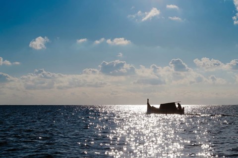 Silhouette of Maltese boat on Mediterranean Sea by Marsaxlokk, south of Malta