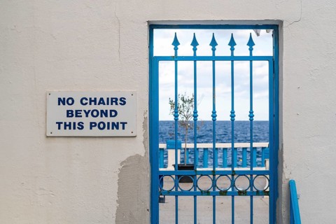 Blue locked door with sign No chairs beyond this point, Malta