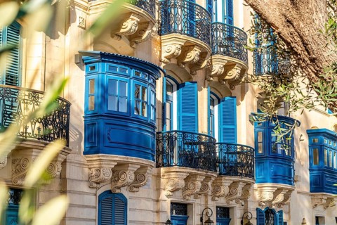 Street with amazing historic houses with colorful wooden balconies in La Valletta, capital city of