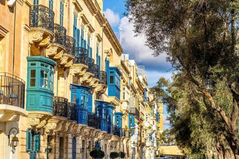 Street with amazing historic houses with colorful wooden balconies in La Valletta, capital city of